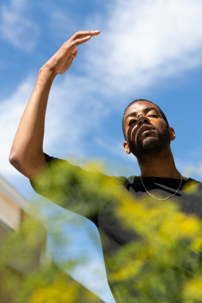 Person shading their face from the sun with their hand while dealing with SSRIs heat intolerance.