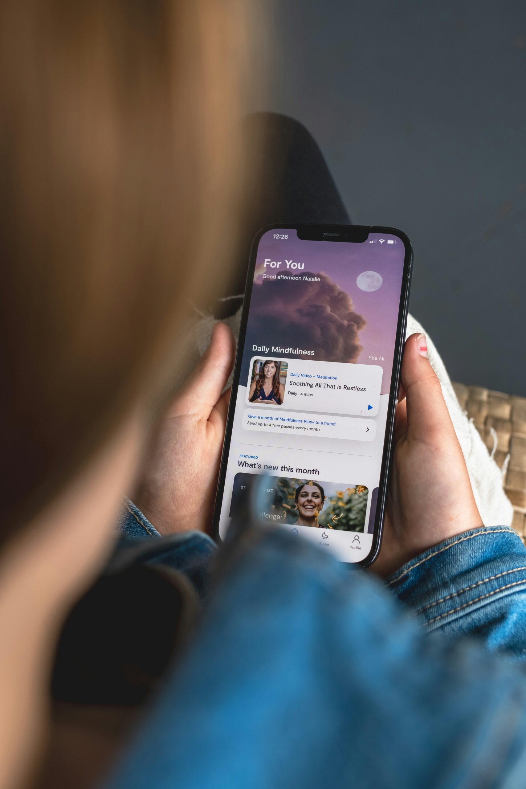 Close up of phone screen that a person is holding and looking at a mental health AI app on the screen.